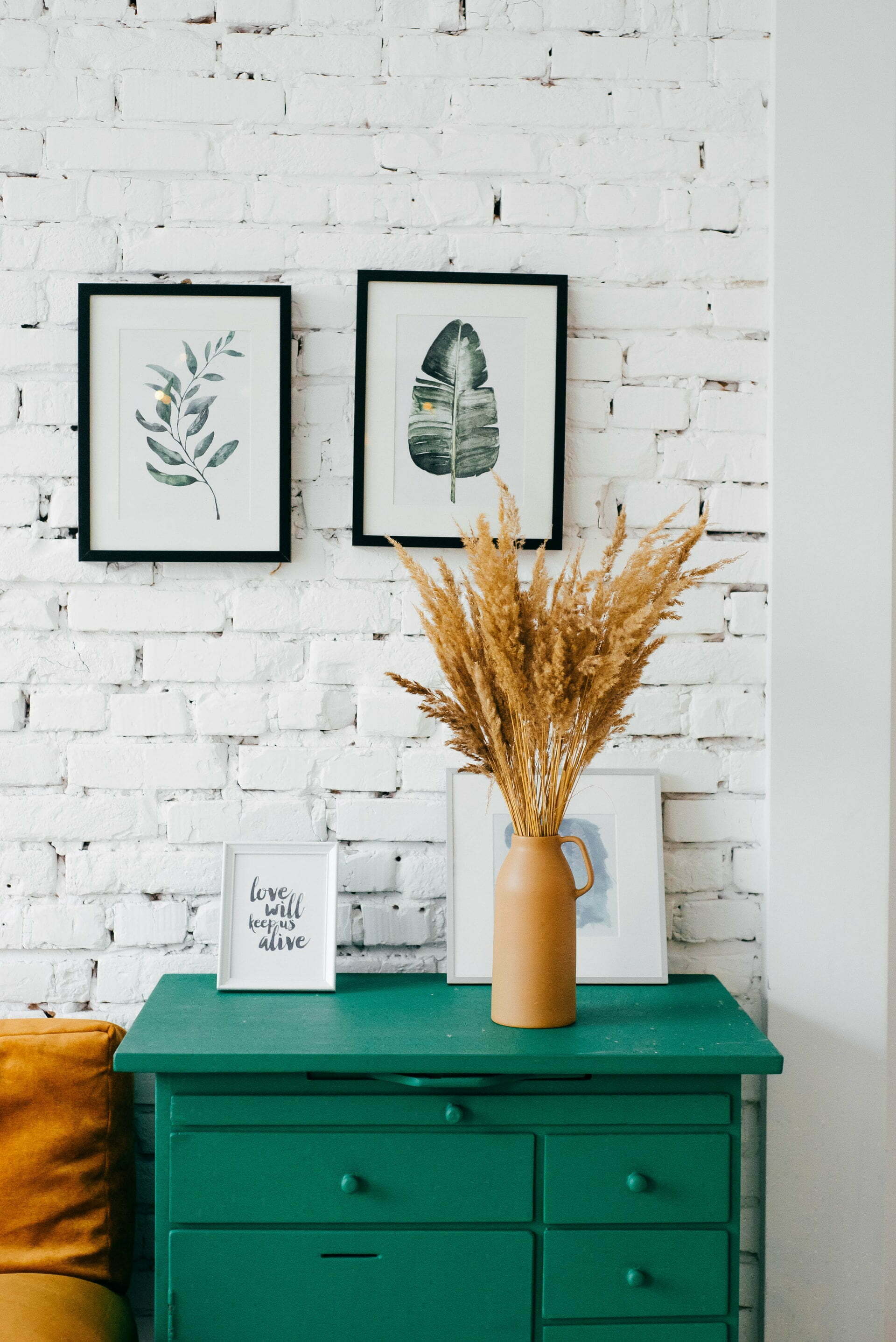 a vase with flowers on top of a dresser