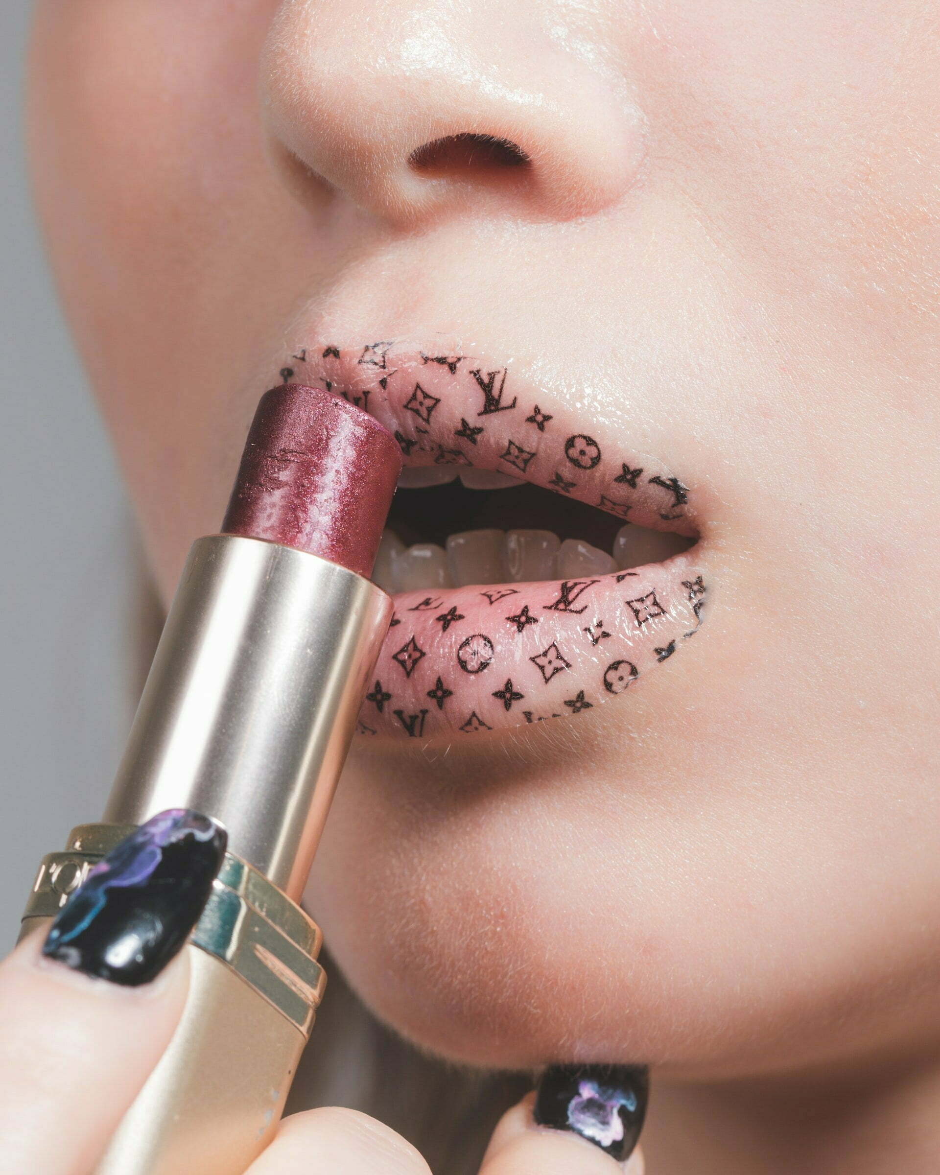 a person with a pink and black lip ring and a silver watch